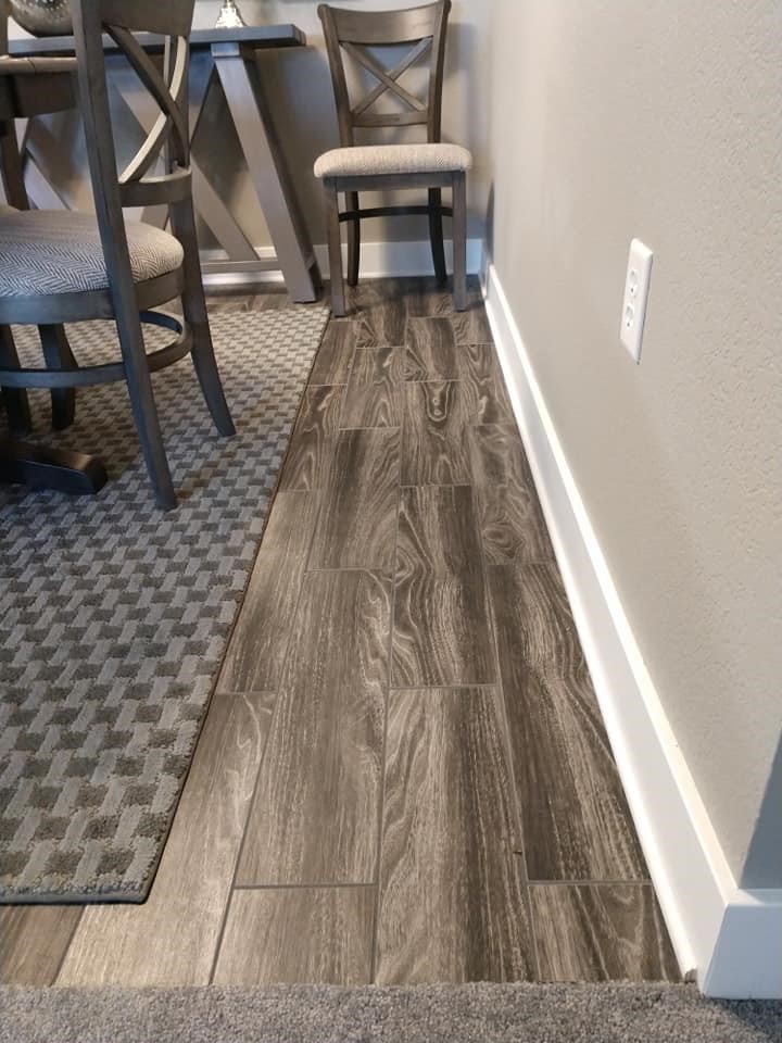wood plank, ceramic tile, dining room, brown, taupe, carpet tile transition, checkerboard rug
